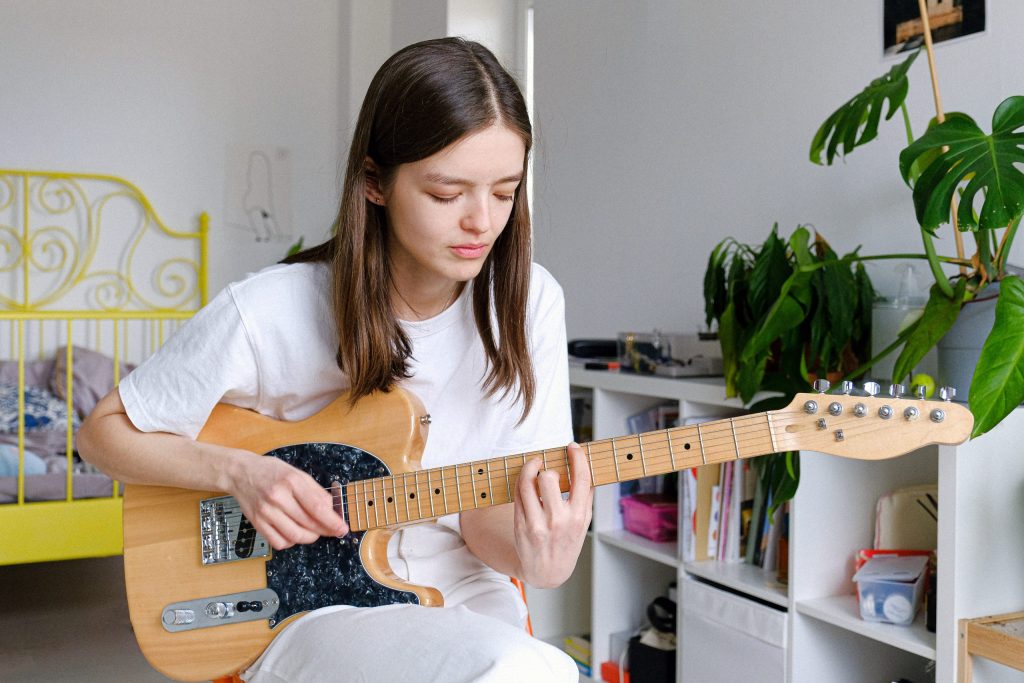 girl learning guitar online